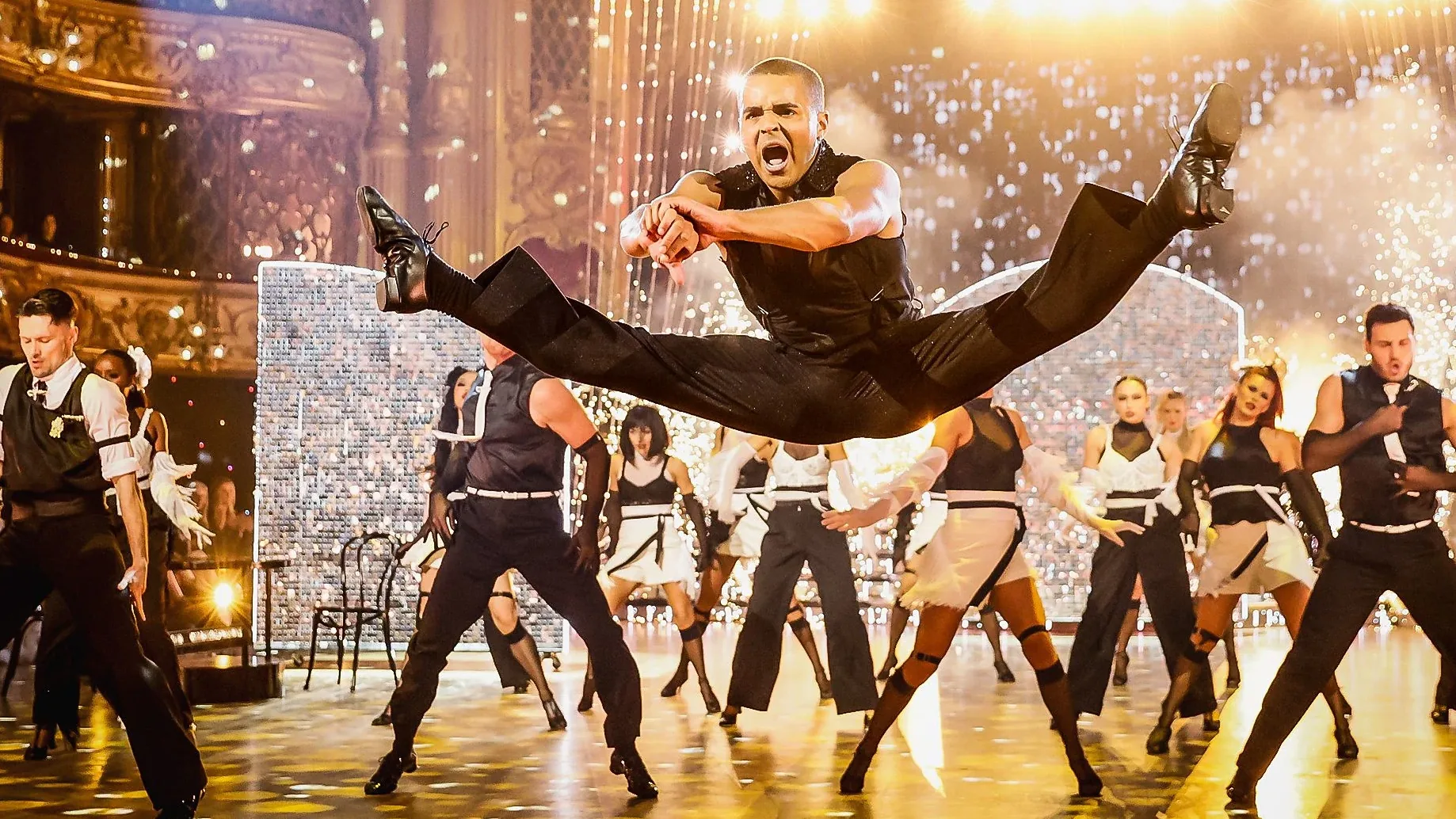 A dancer mid-leap above the company on the Strictly Come Dancing floor