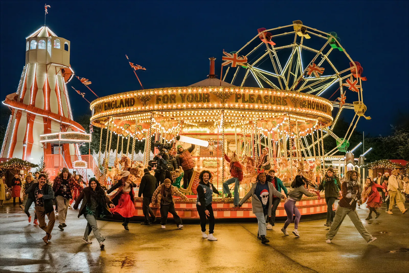 Dancers in front of a lit carousel on Christmas Karma