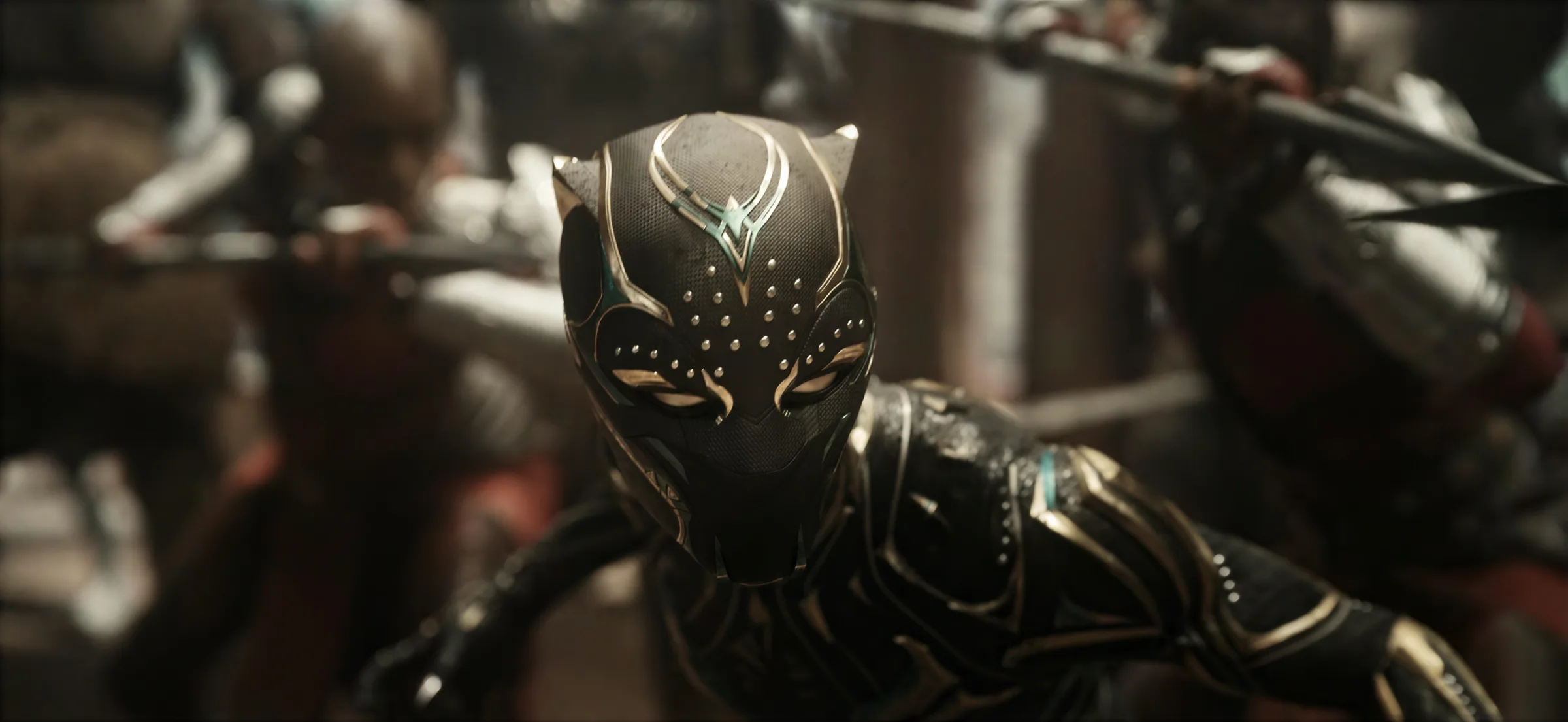 Still from Avengers: Doomsday: a mask in close-up, warriors with spears blurred behind