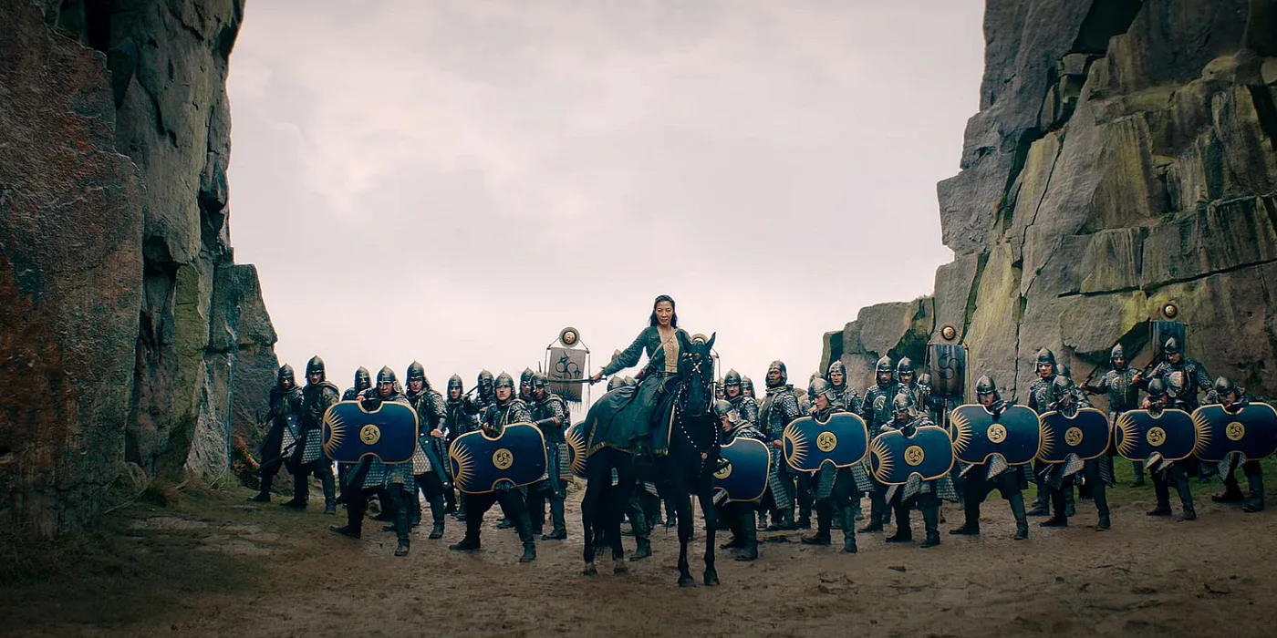 A rider leading a shield wall of armoured soldiers through a rocky pass, in The Witcher